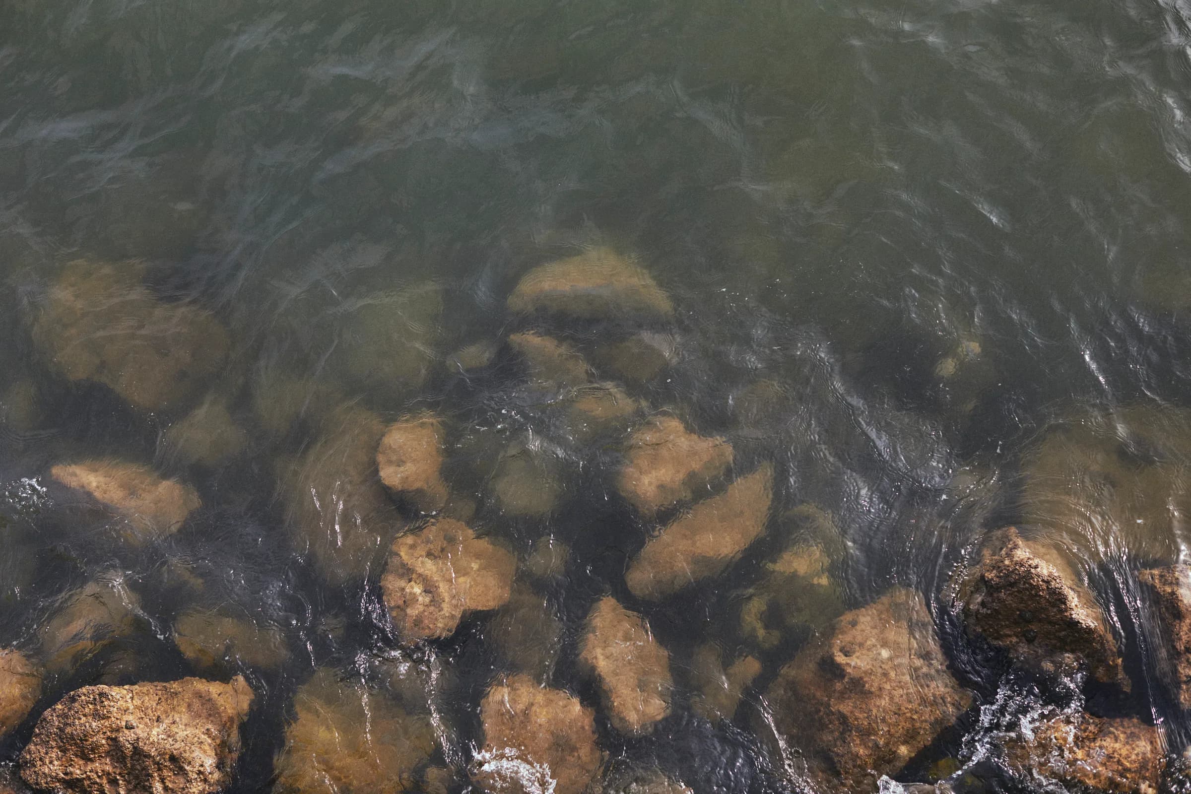 Rocas bajo el agua clara, vistas desde arriba