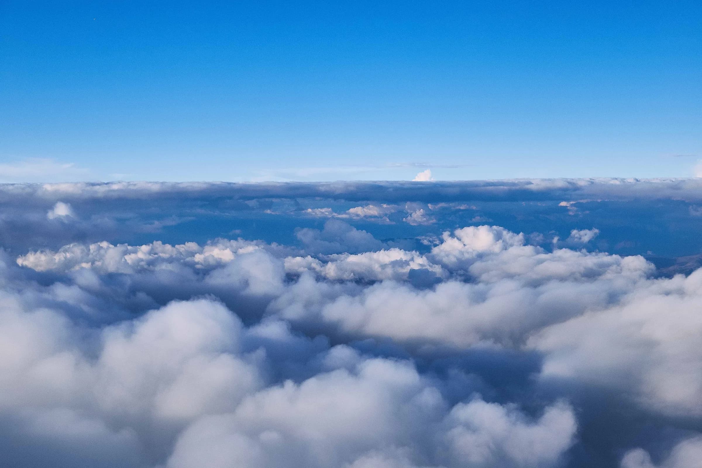 Mar de nubes bajo un cielo azul, visto desde el aire
