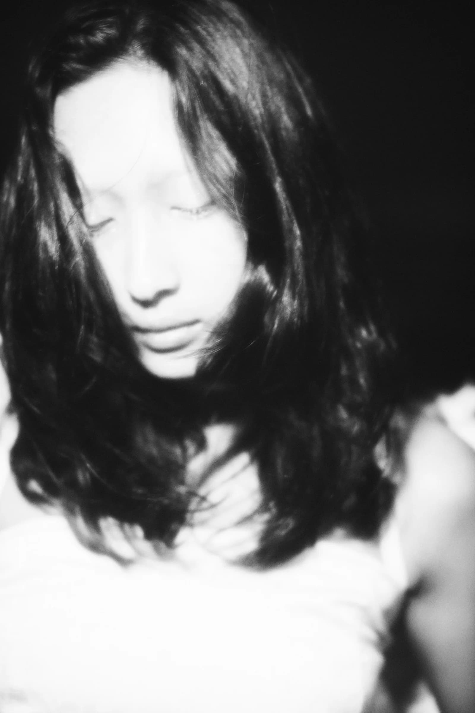 Retrato en blanco y negro de mujer de cabello largo con los ojos cerrados