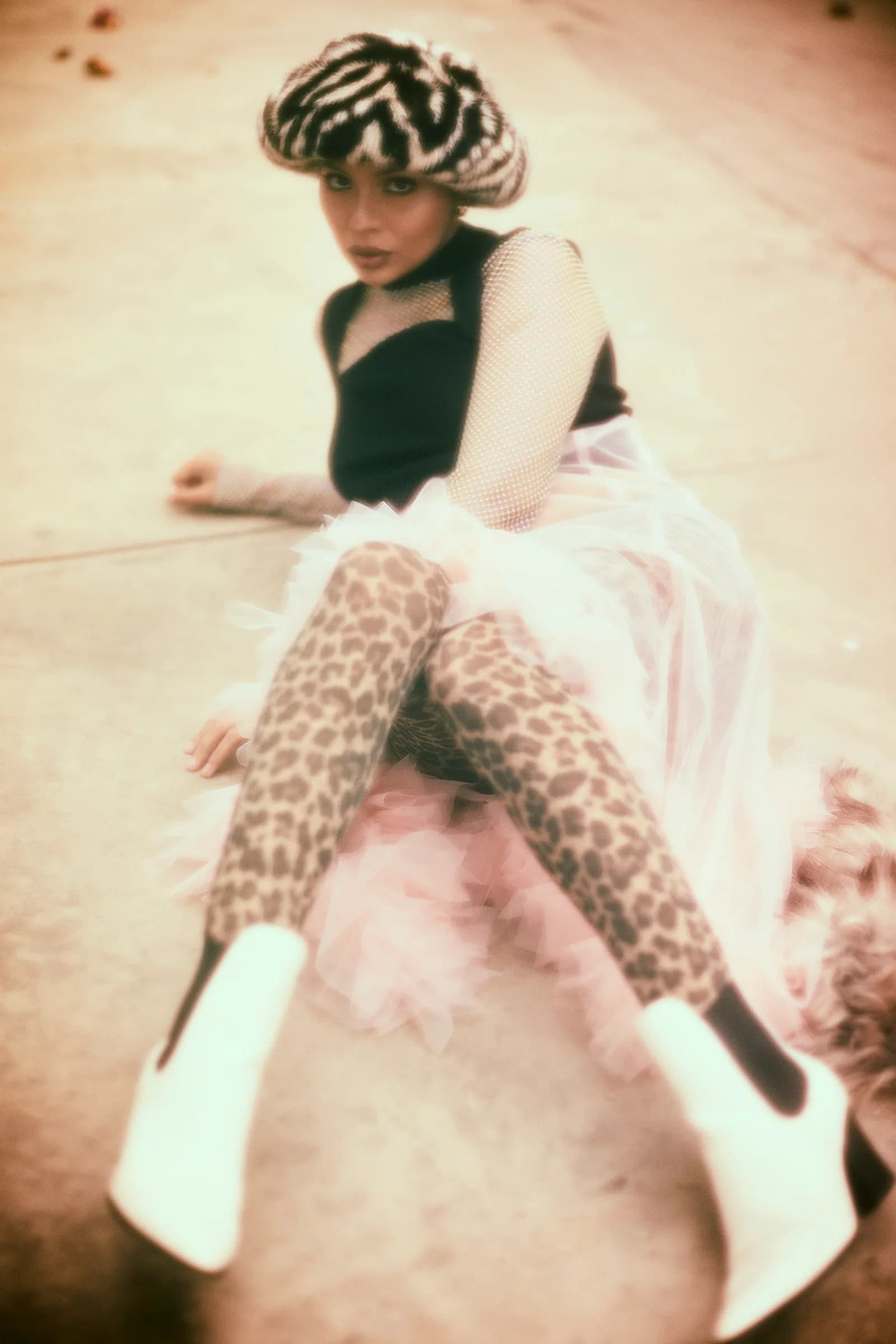 Retrato editorial de mujer con boina de cebra y medias de leopardo