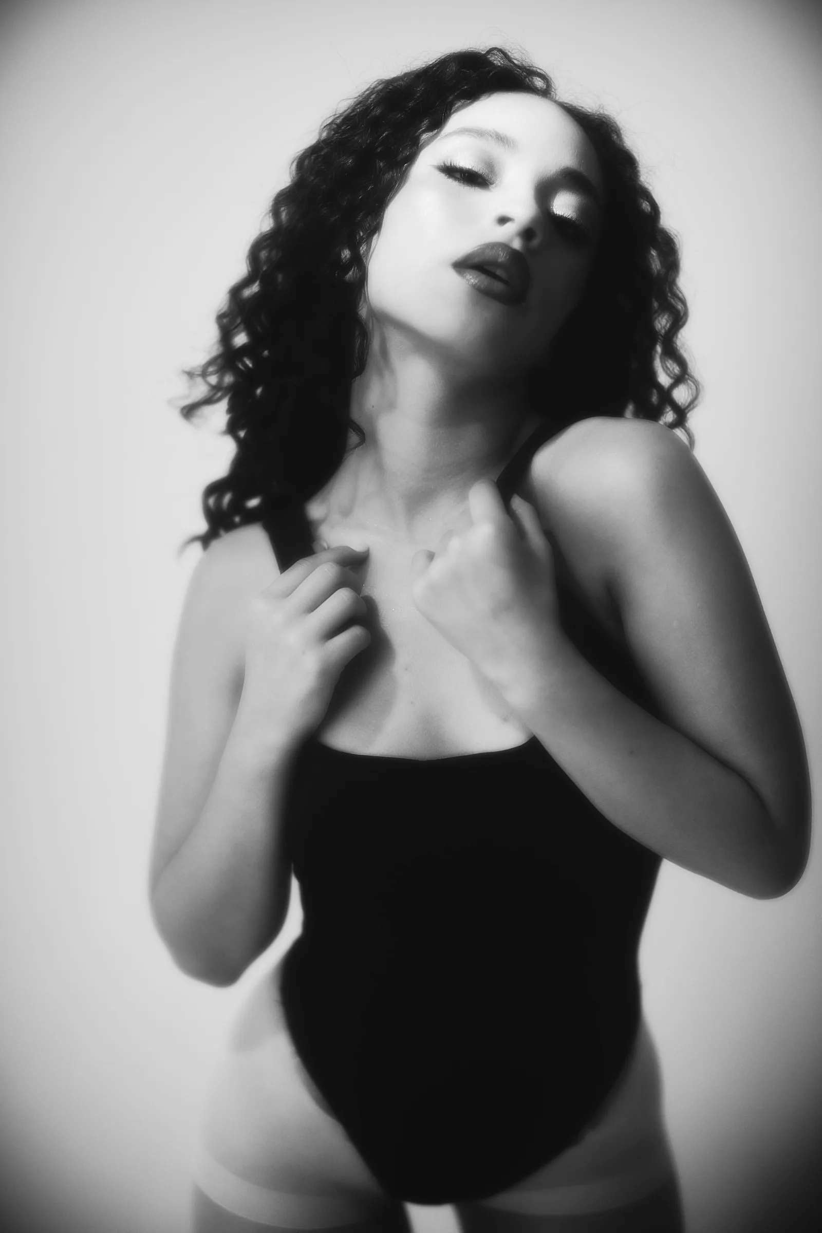 Retrato en blanco y negro de mujer de cabello rizado con body negro