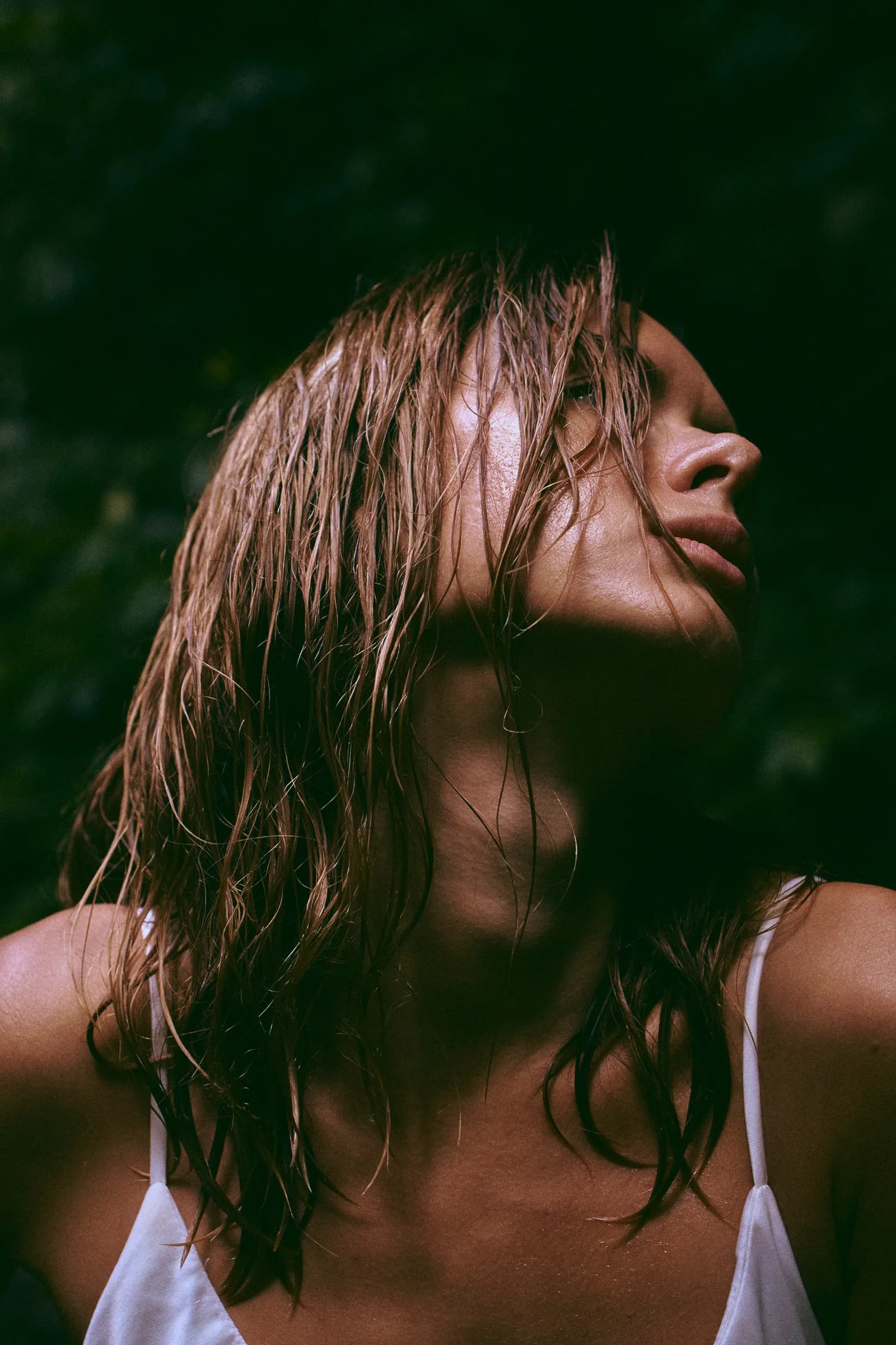 Primer plano de mujer con el cabello mojado mirando hacia arriba