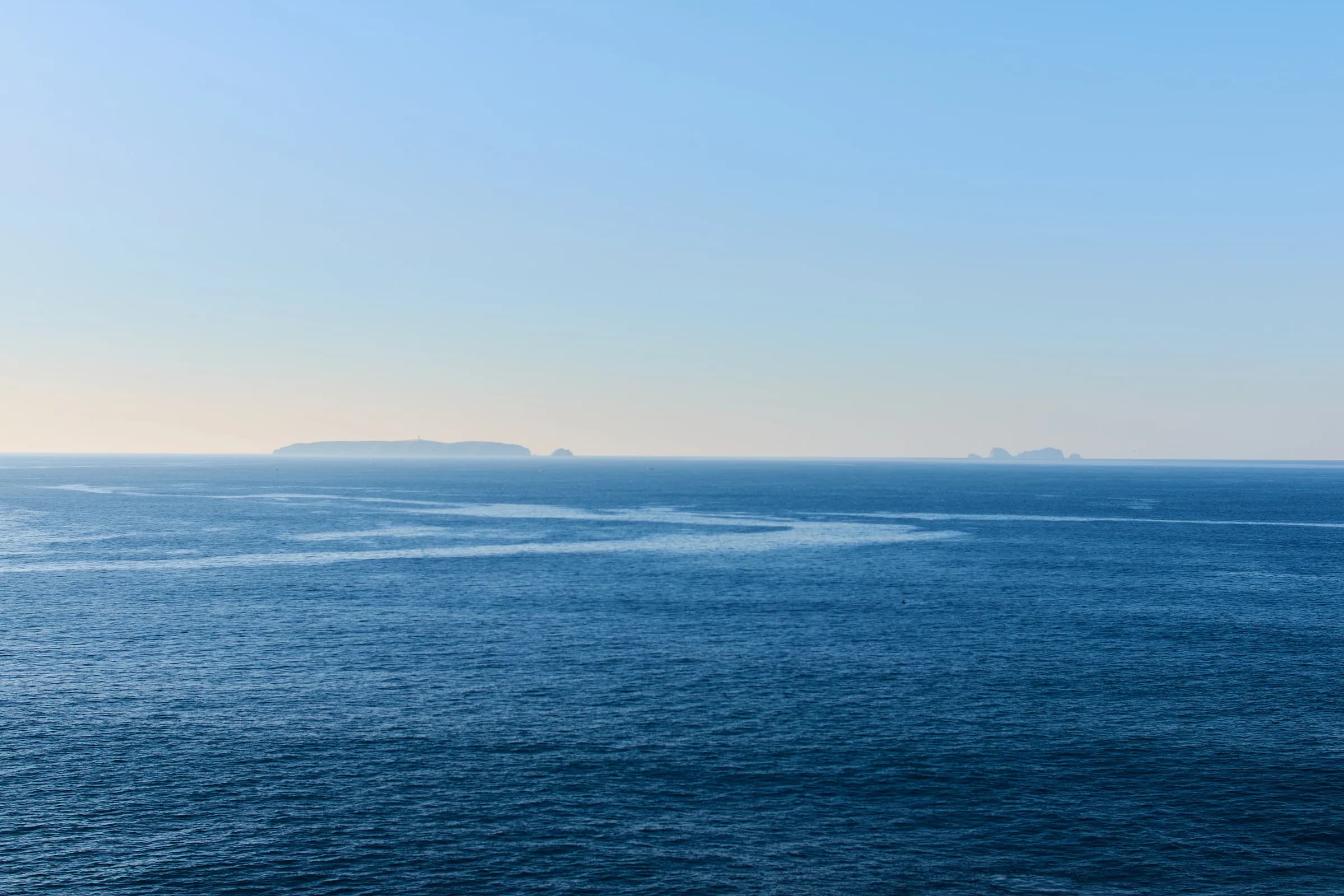 Mar abierto en calma con islas en el horizonte