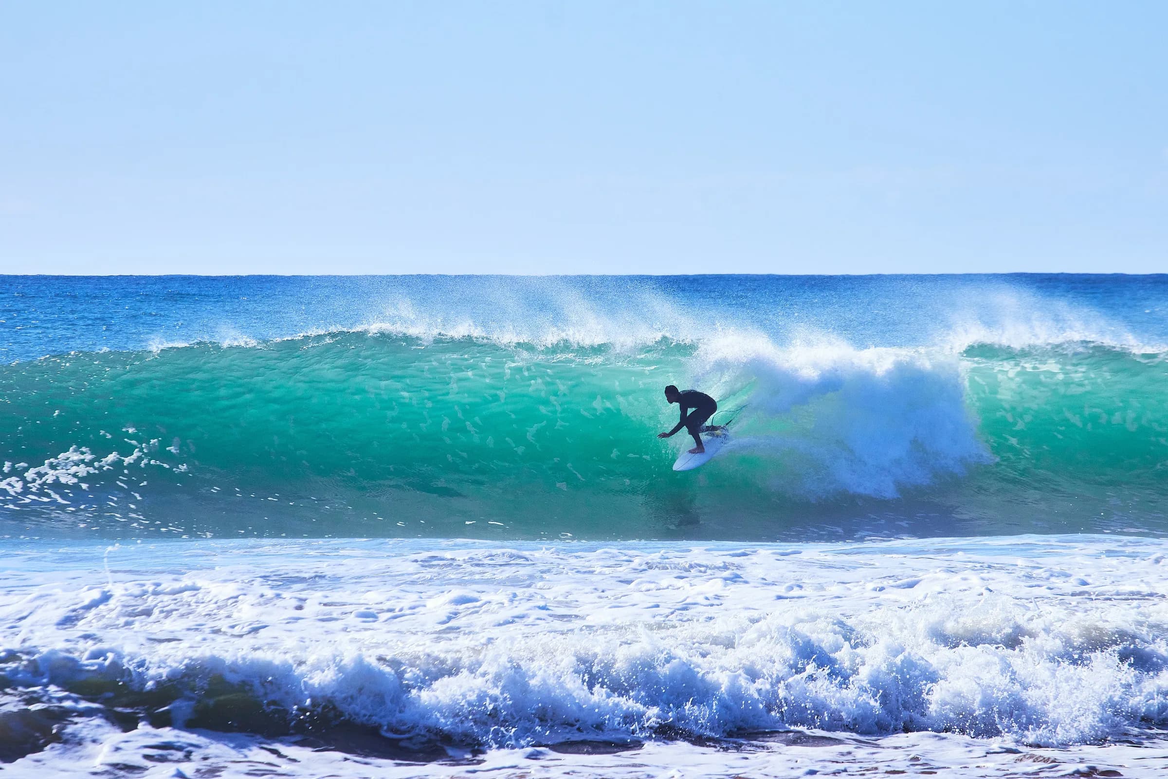 Surfista girando dentro de una ola turquesa