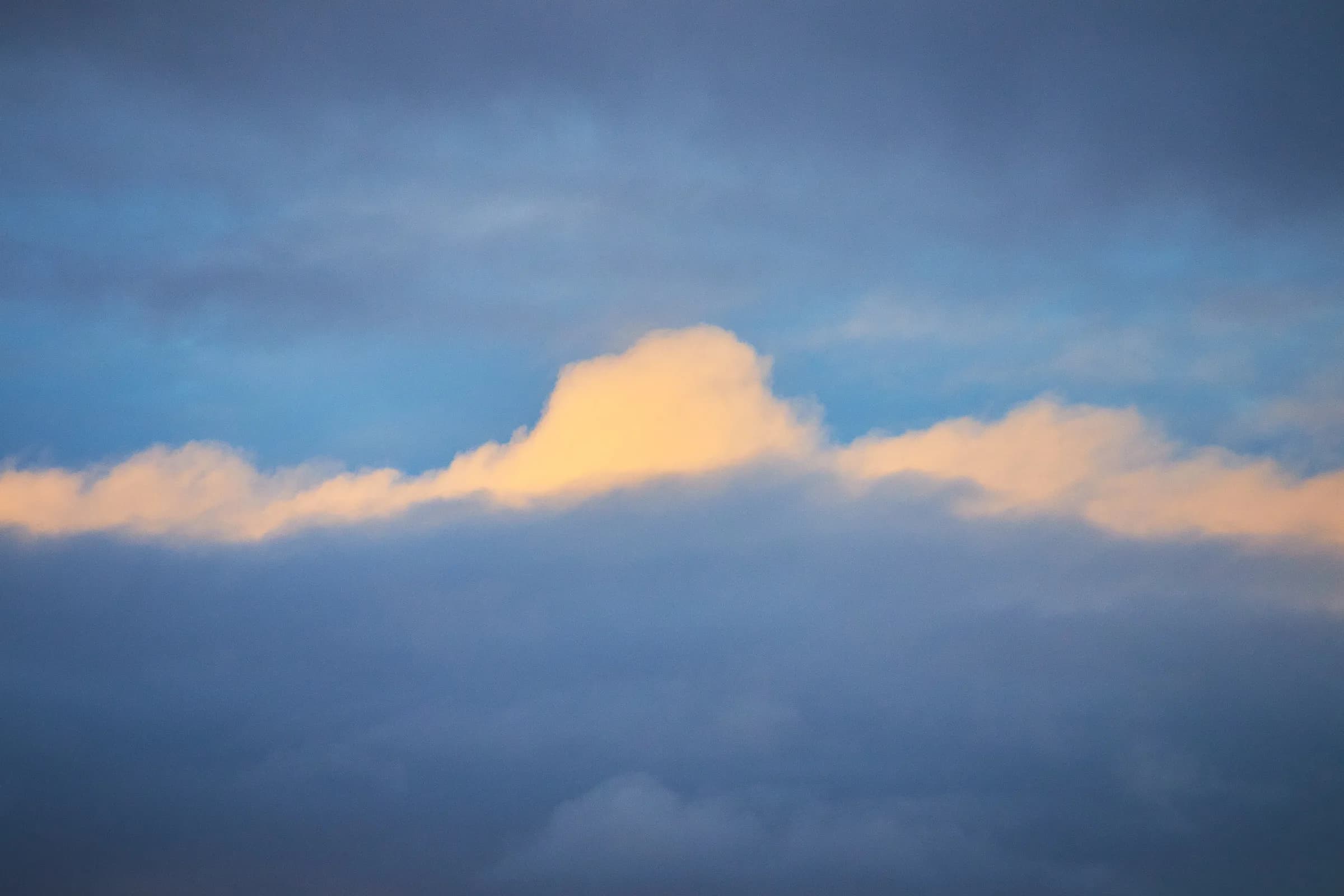 Nube iluminada por el sol en un cielo azul profundo
